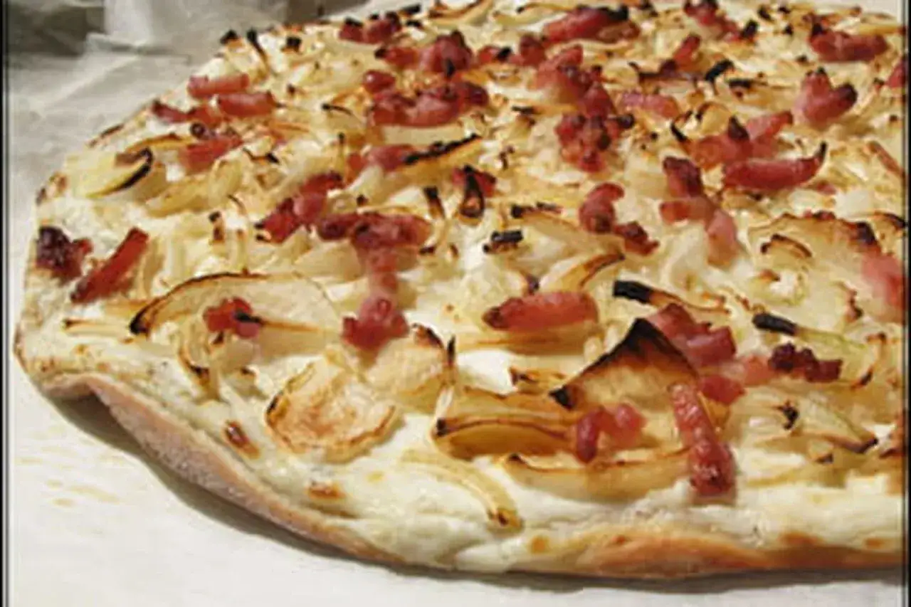 Flamenkuch d'origine, une tarte fine garnie d'oignons et de lardons, croustillante et savoureuse.