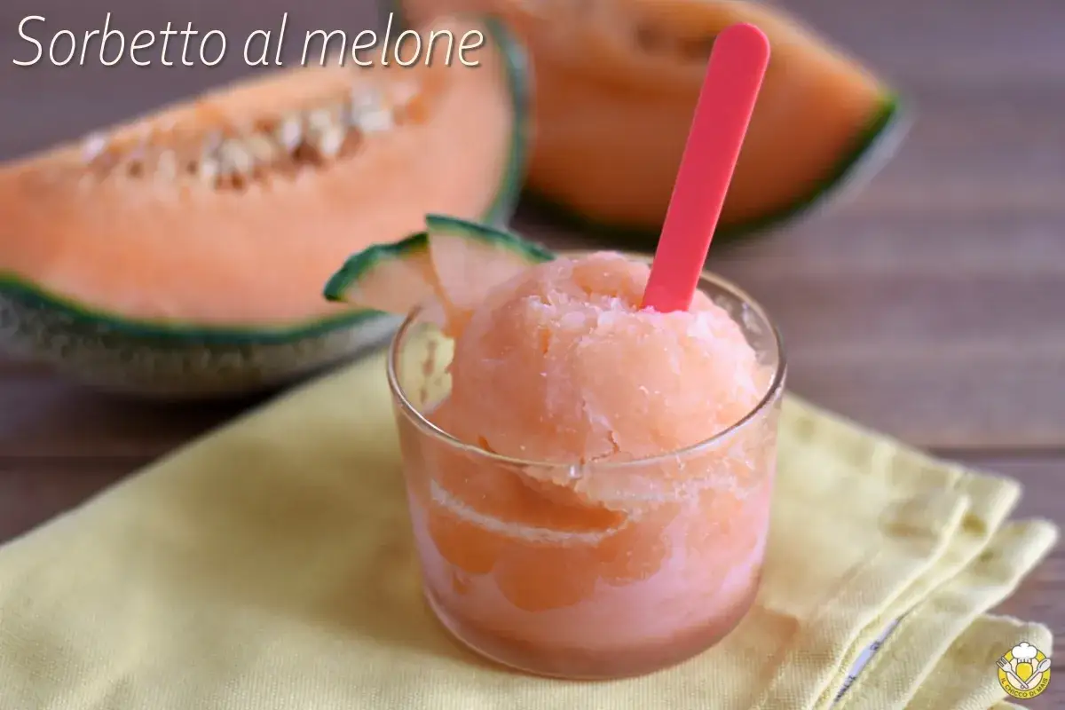 Sorbetto al melone rinfrescante in un bicchiere, con fette di melone fresco sullo sfondo.