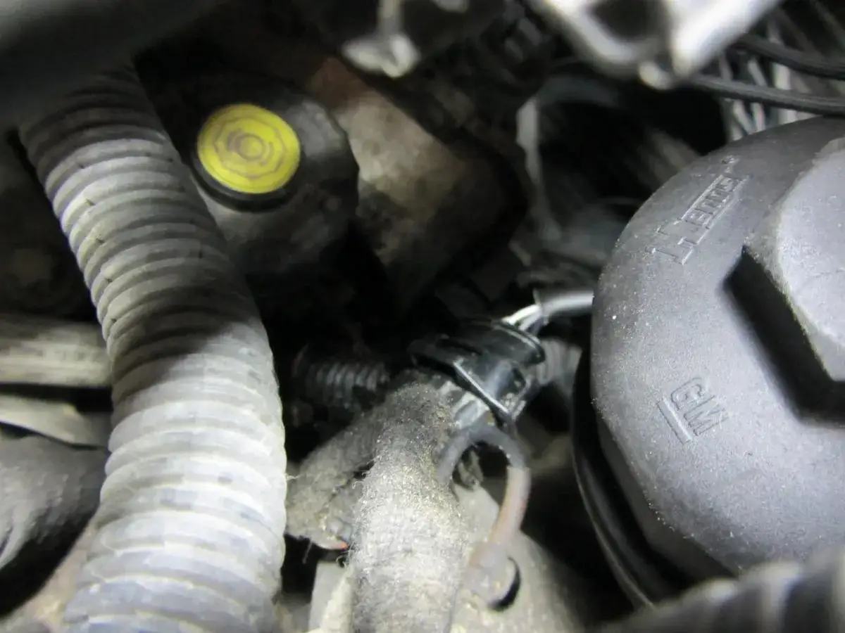 Silnik Peugeot z błędem DTC P0170. Widoczny przewód, filtr oleju GM i żółta zakrętka.