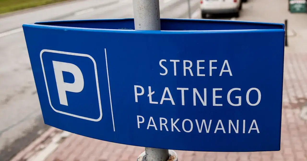 Niebieski znak informuje o strefie płatnego parkowania. Motocykl zaparkowany w tym miejscu wymaga uiszczenia opłaty.