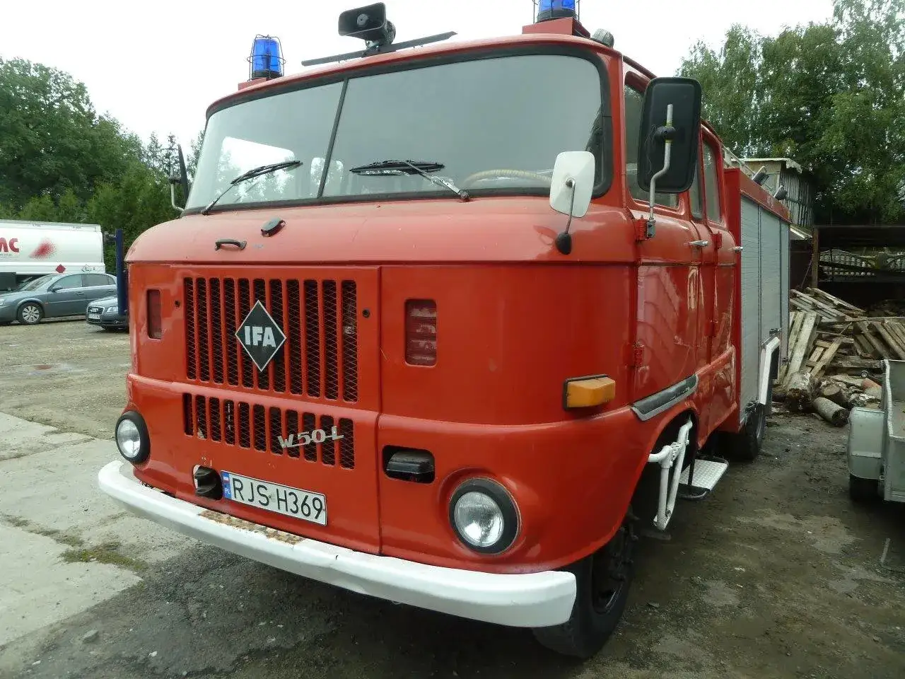 Czerwony wóz strażacki IFA W50L z tablicą rejestracyjną RJS H369, gotowy do akcji.