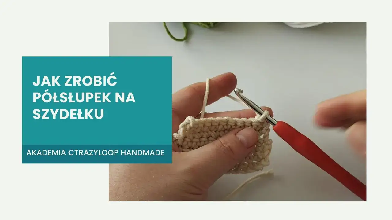 Ręka trzymająca szydełko z czerwonym uchwytem, tworząca p&oacute;łsłupek na beżowej wł&oacute;czce. Napis 