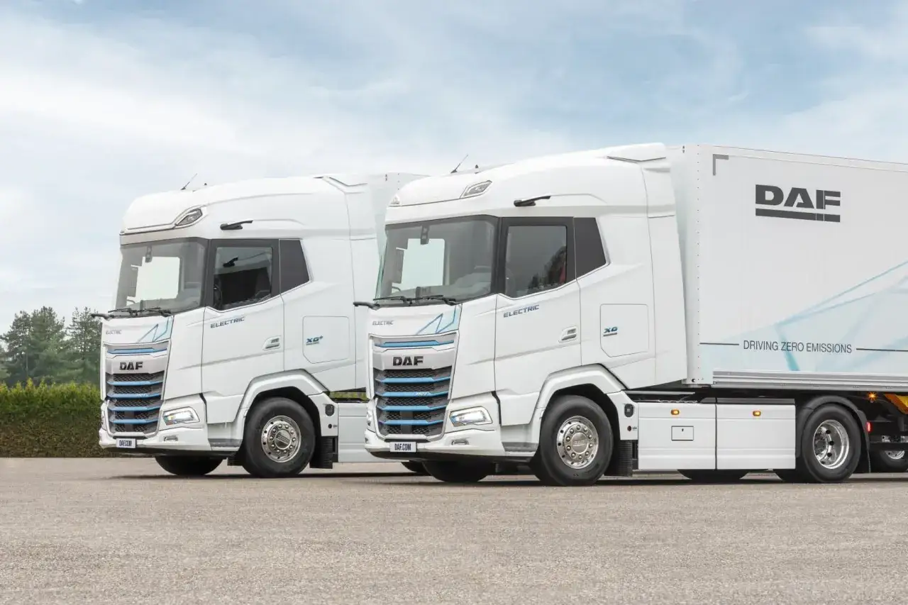 Dos camiones DAF XG Plus eléctricos blancos, listos para la carretera, con el lema 