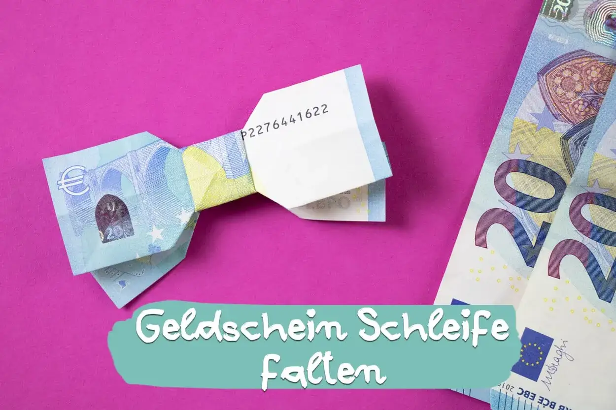 Eine gefaltete Geldschein-Schleife auf pinkem Hintergrund. Daneben liegen weitere 20-Euro-Scheine.