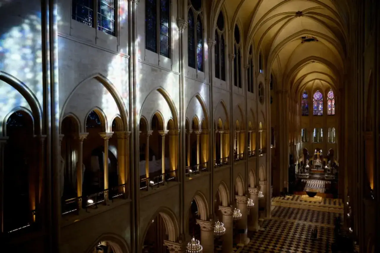 Wnętrze katedry Notre Dame, gdzie światło z witraży maluje ściany, tworząc magiczną atmosferę.