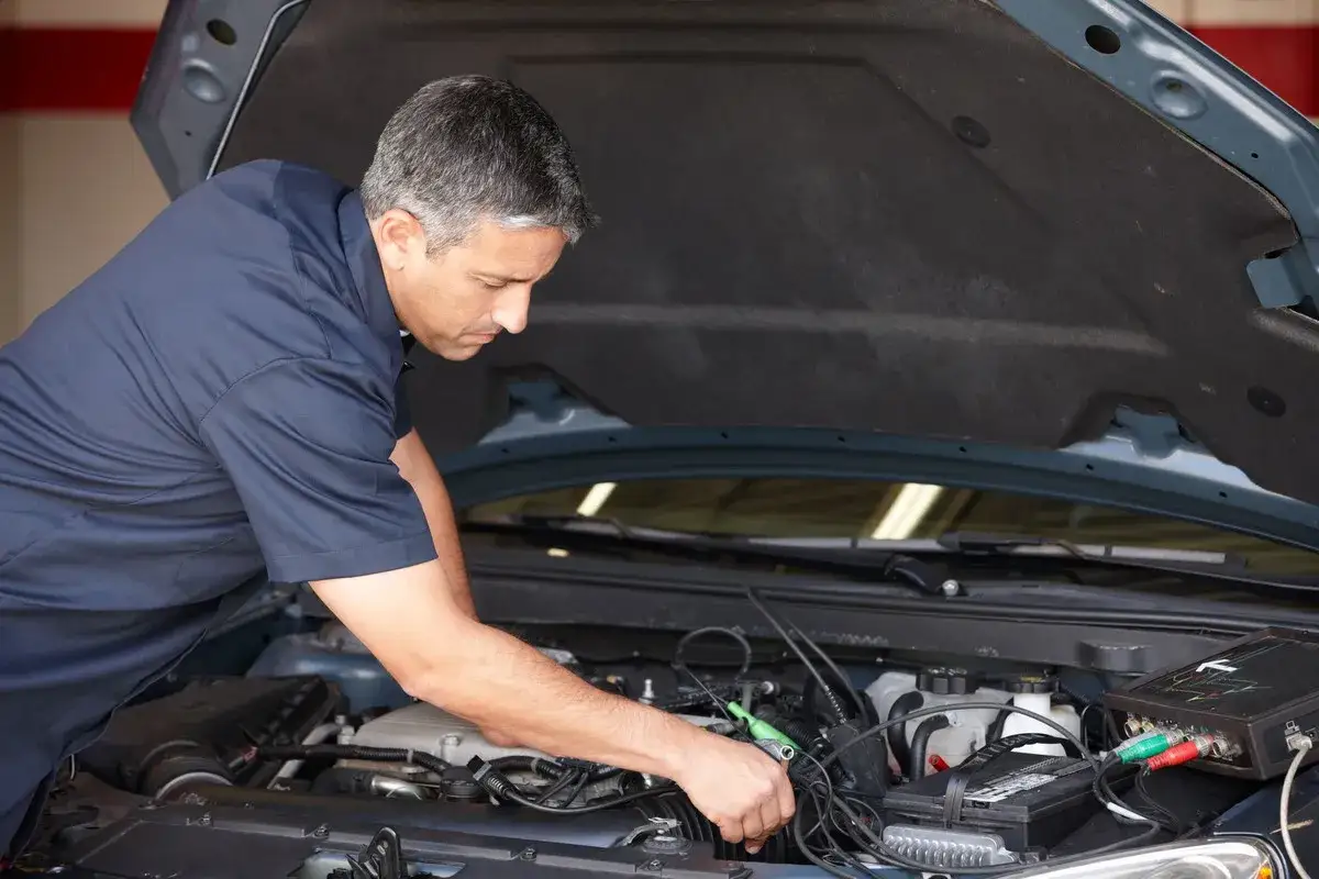 Mécanicien examinant le moteur d'une voiture qui a du mal à démarrer diesel. Diagnostic d'un problème moteur.