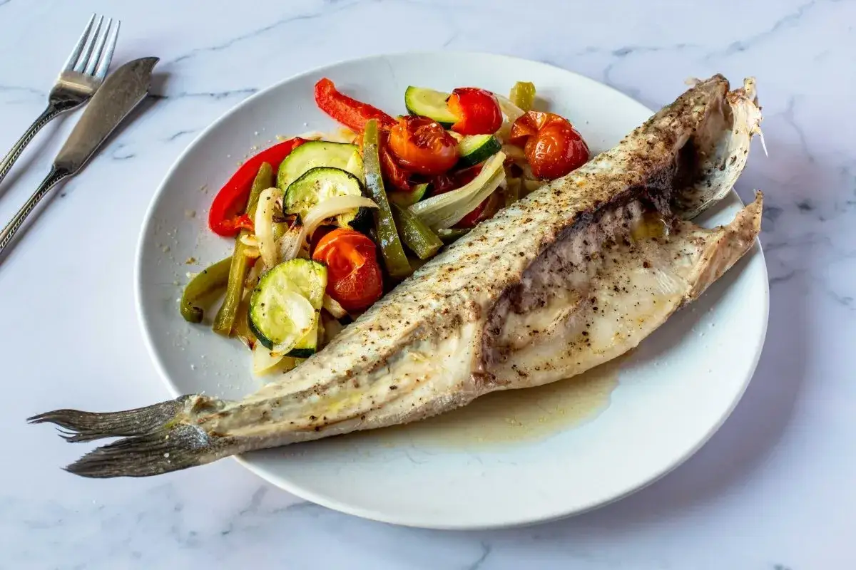 Lubina en papillote con verduras asadas: pimientos, calabacín, cebolla y tomates cherry. Un plato saludable y delicioso.