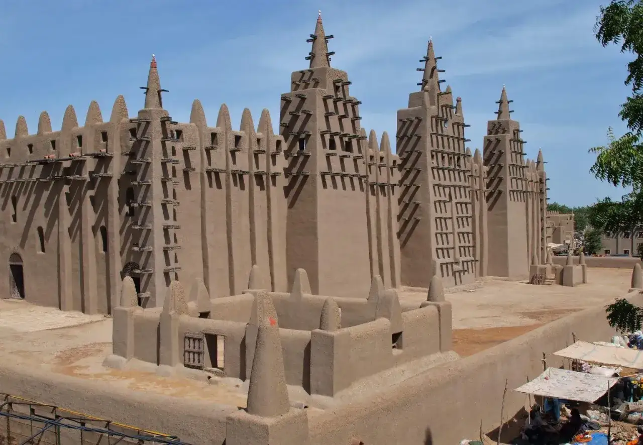 Wielki Meczet w Dżenne, kraj z Bamako, z charakterystycznymi drewnianymi belkami i stożkowymi wieżyczkami.