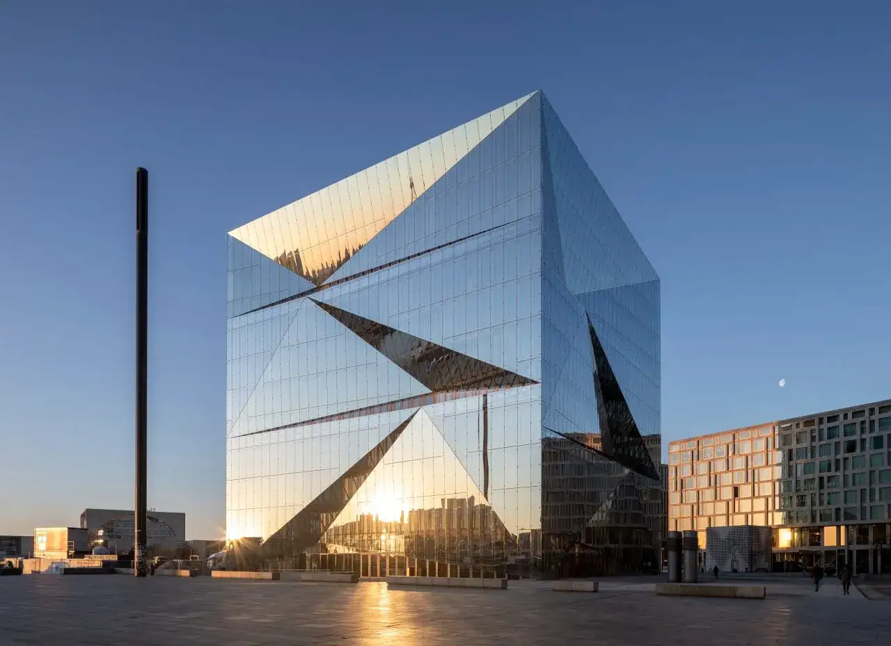 Edificio de cristal facetado refleja el sol poniente, creando un deslumbrante factor solar.