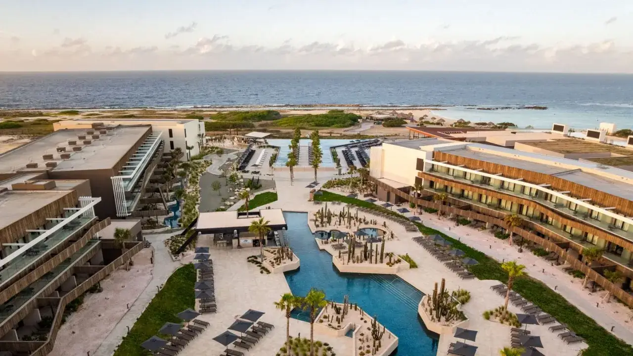 Nowoczesny resort z basenami i kaktusami, gdzie jest Aruba, tuż przy turkusowym morzu.