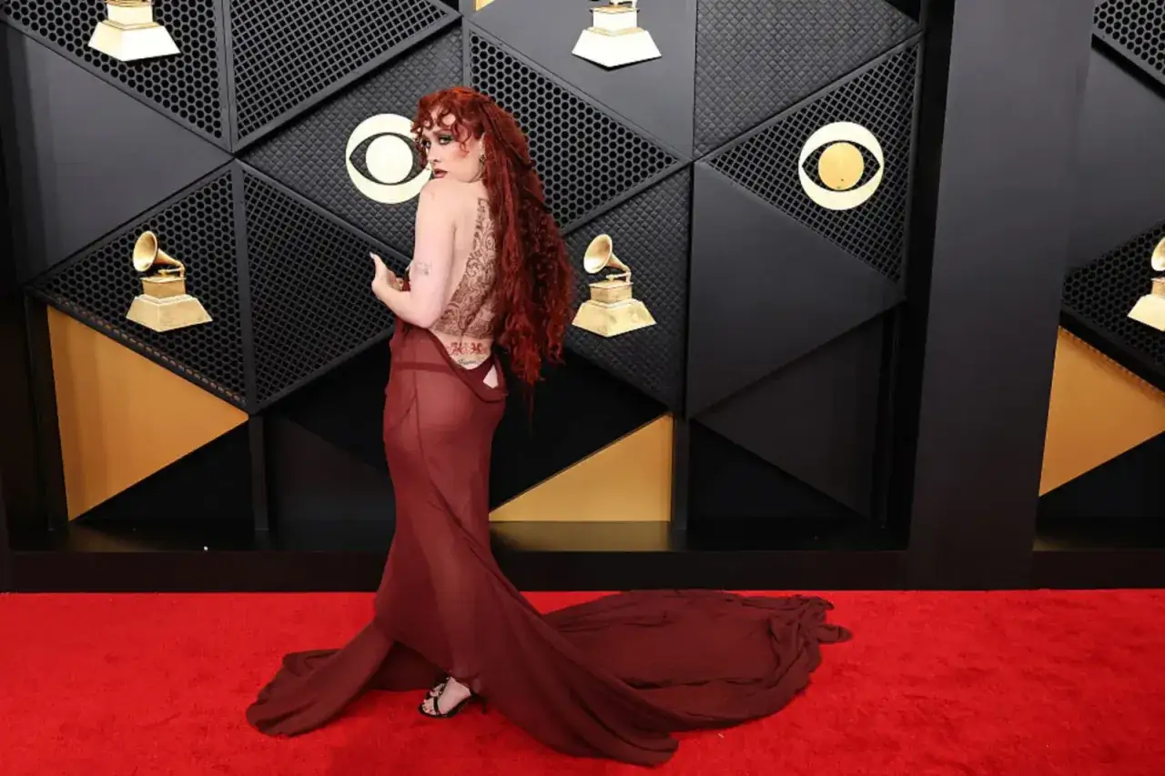 Chappell Roan i sin dramatiska Grammy-outfit, med en genomskinlig vinr&ouml;d kl&auml;nning och intrikat ryggtatuering, p&aring; r&ouml;da mattan.