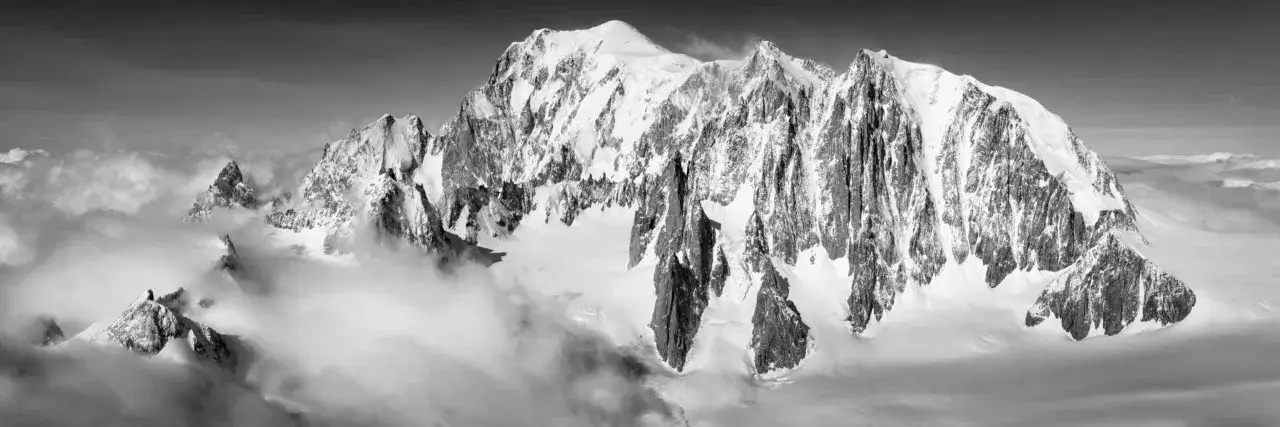Majest&auml;tische, schneebedeckte Gipfel ragen aus Wolken empor. Hier liegt der Mont Blanc, ein atemberaubendes Panorama der Alpen.