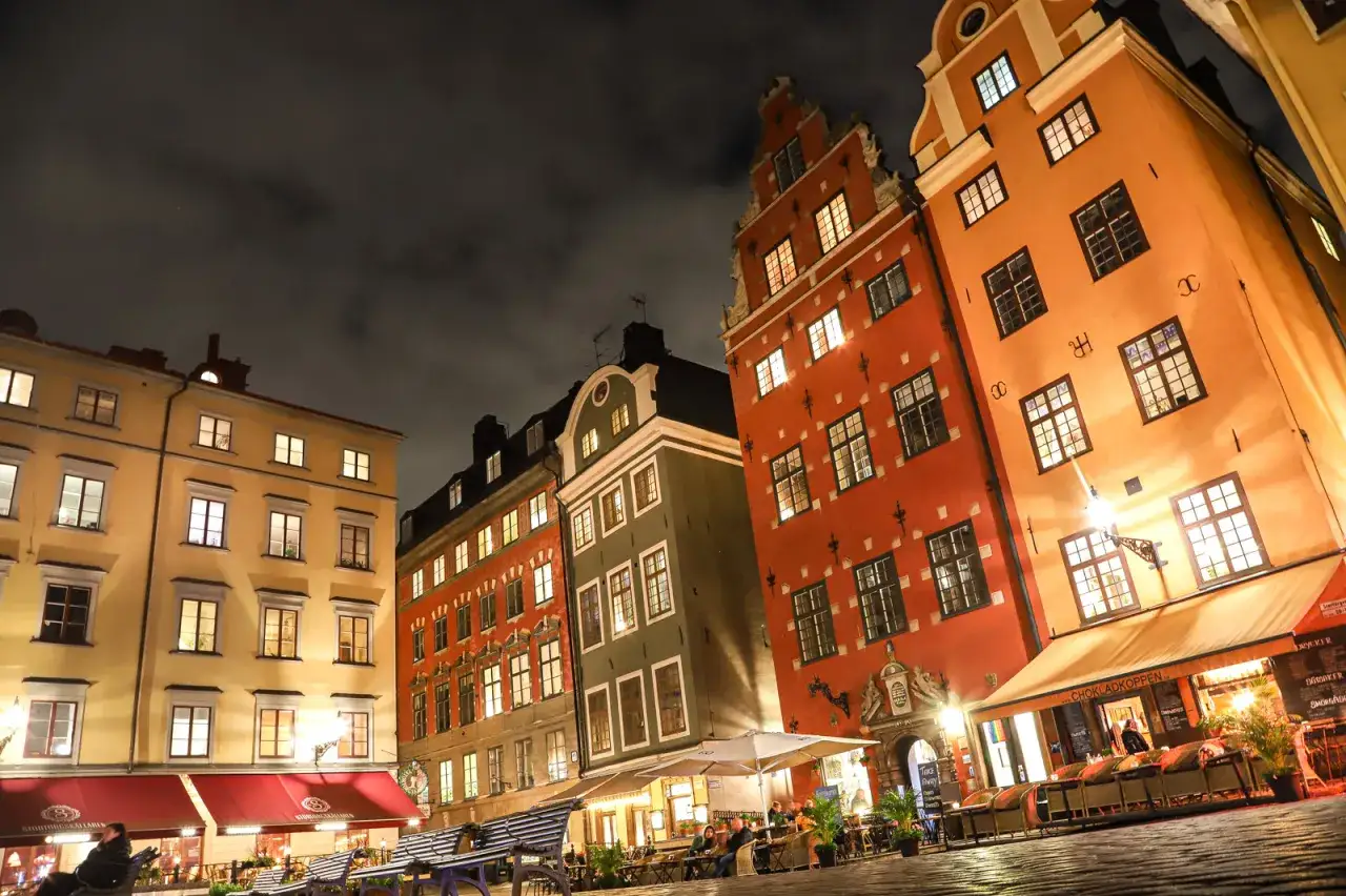 La nuit tombe sur Stockholm. Que faire à Stockholm ? Admirez ces façades colorées illuminées, dînez en terrasse.
