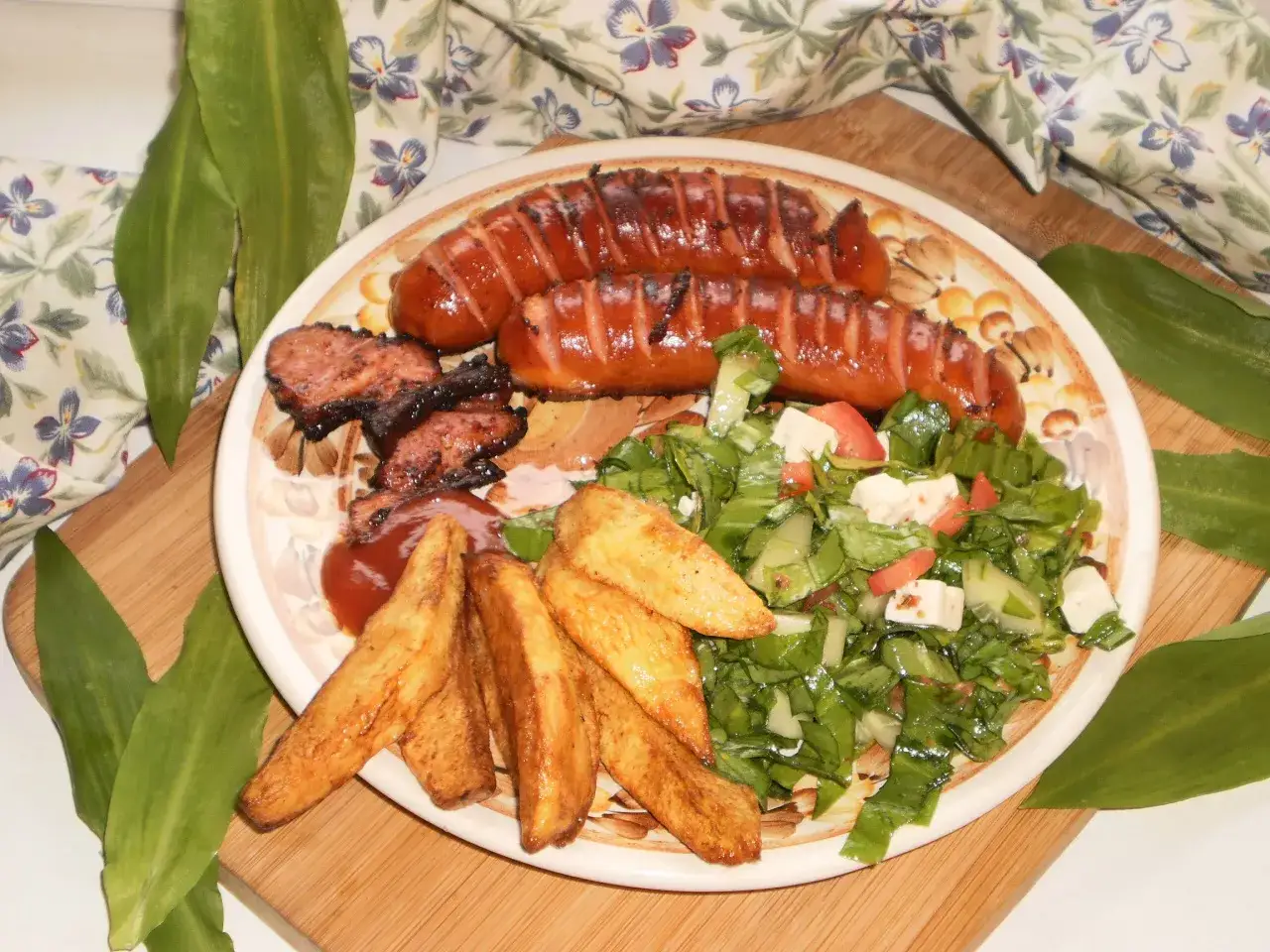 Idealne danie co na ognisko: grillowane kiełbaski, kawałki mięsa, frytki i sałatka.
