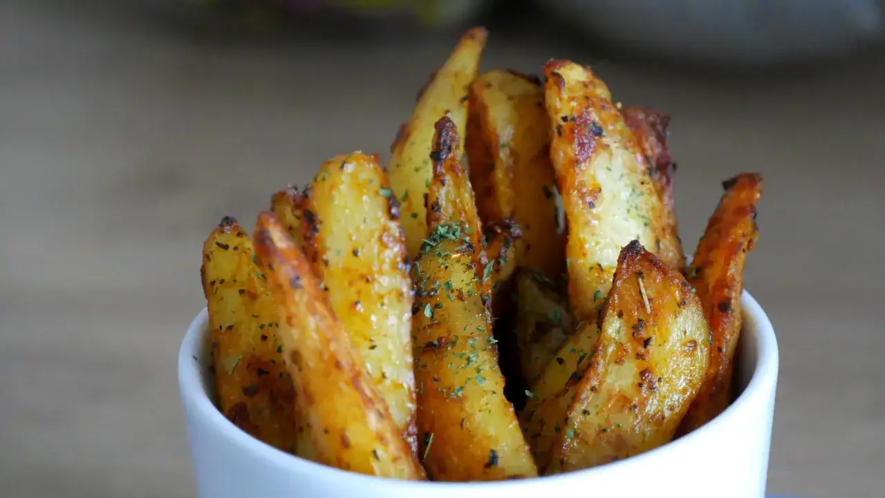 Un bol de frites au four dor&eacute;es et croustillantes, saupoudr&eacute;es d'herbes. Un d&eacute;lice simple et r&eacute;confortant.