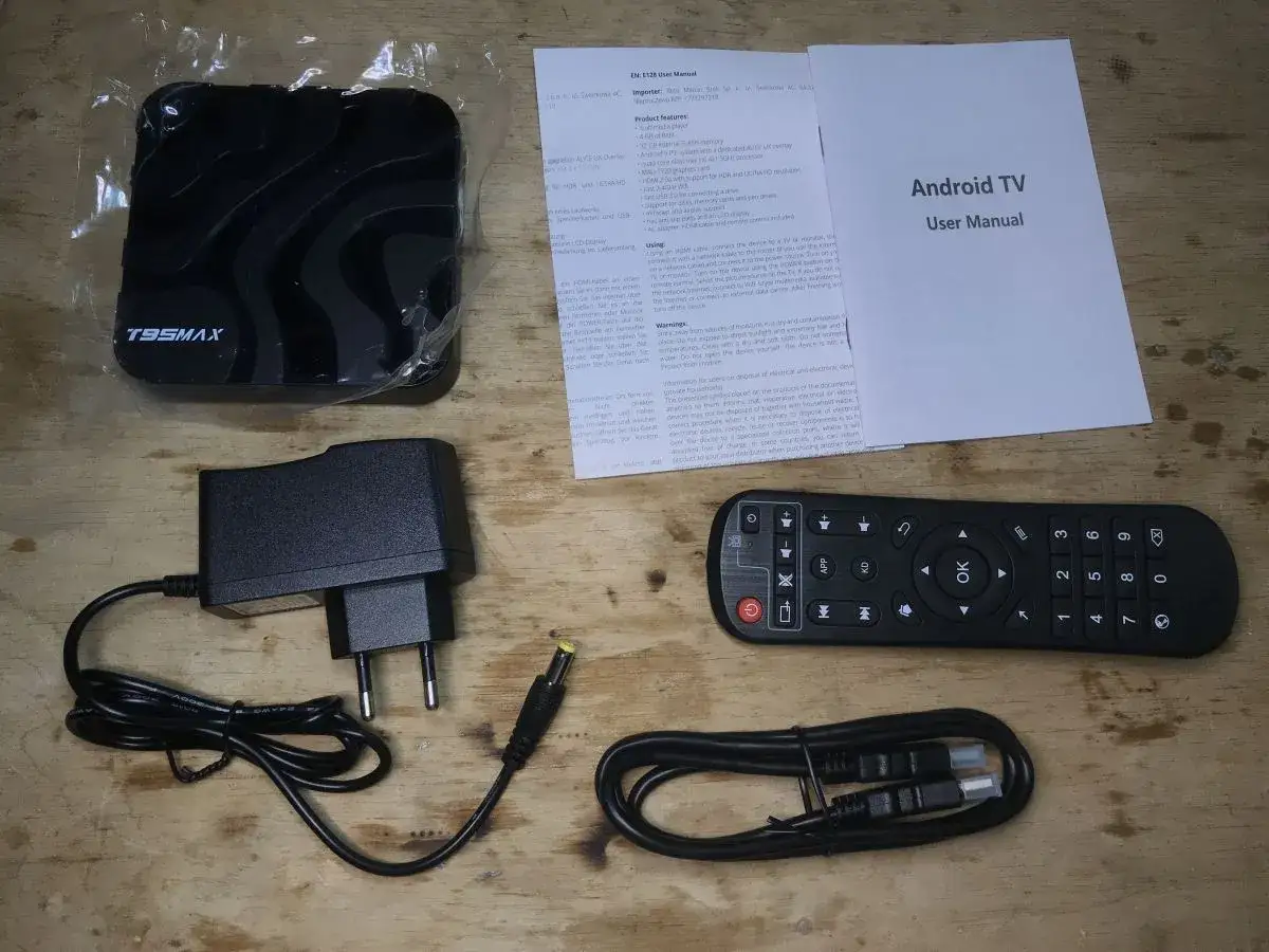 Zestaw smart tv box: urządzenie, pilot, zasilacz i kable. Instrukcja wyjaśnia, jak działa.