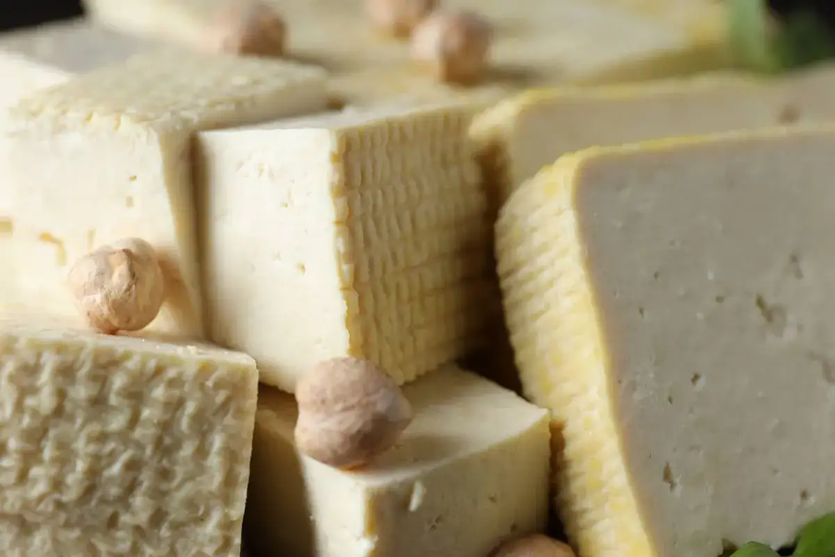 Kostki tofu, niektóre z kratkowaną fakturą, z ciecierzycą. Dowiedz się, jak smakuje tofu – delikatne i wszechstronne.