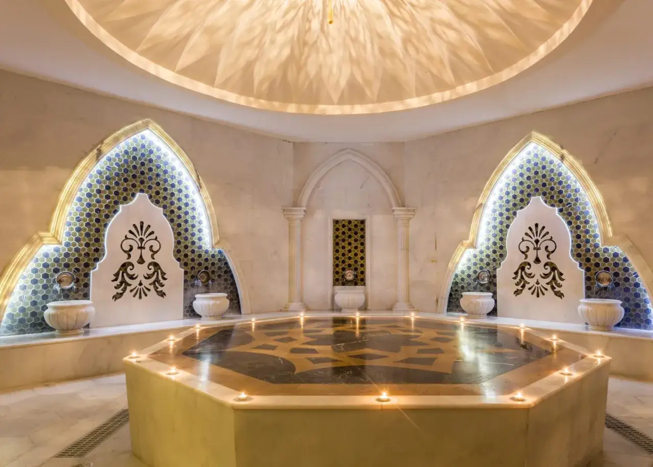Luksusowy hammam, co to? Wnętrze z kopułą, mozaikami, kranami i świecami tworzy atmosferę relaksu.