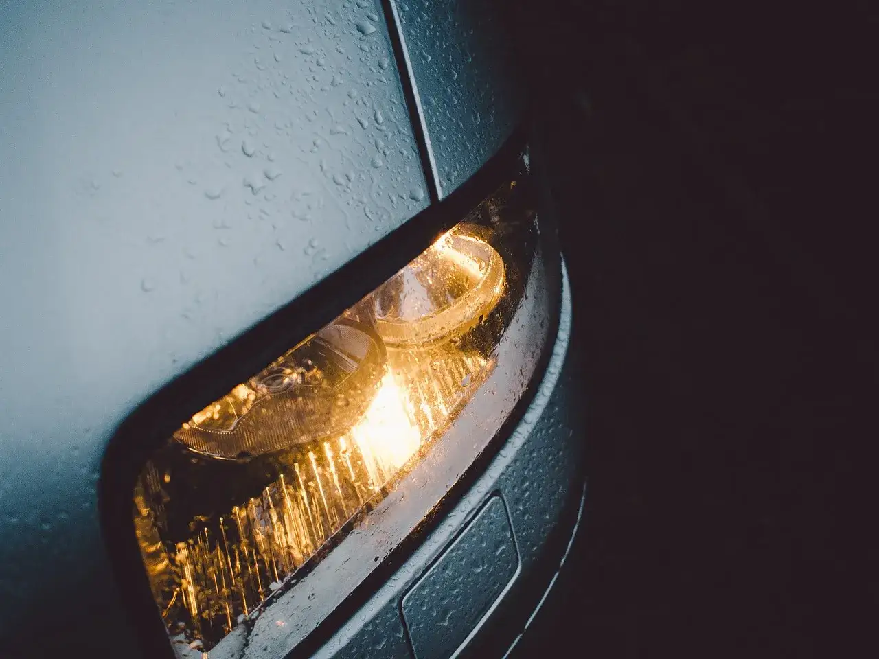 Świecąca lampa Peugeota 206 w deszczu. Dowiedz się, jak wymienić żarówkę w tym modelu.