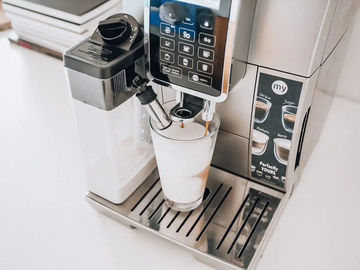 Ekspres DeLonghi przygotowuje kawę, która ma dziwny smak. Na panelu widoczne są profile użytkowników: Grace, Jurgen, Nathalie, Boris.