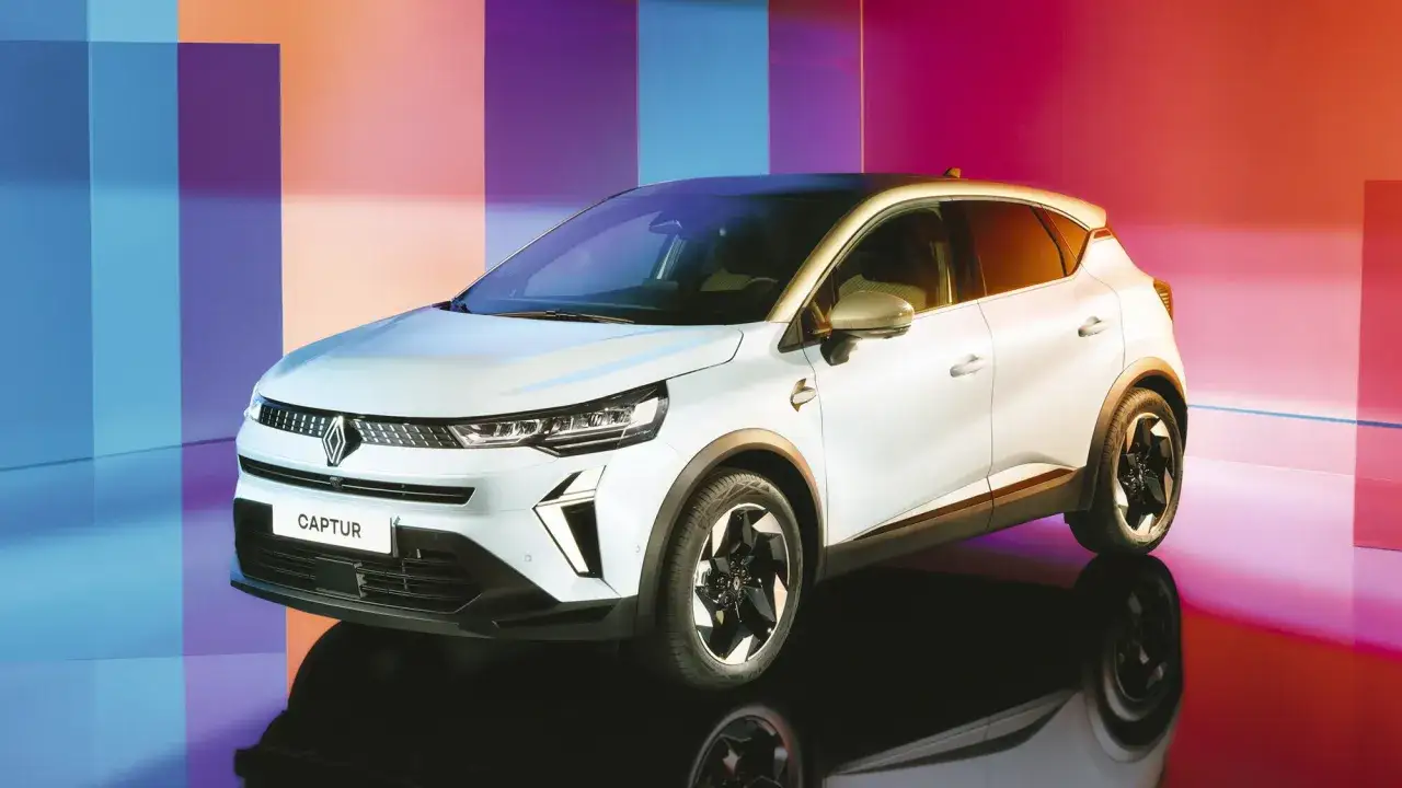 Renault Captur bianco, uno dei migliori SUV full hybrid 2026, con sfondo colorato.