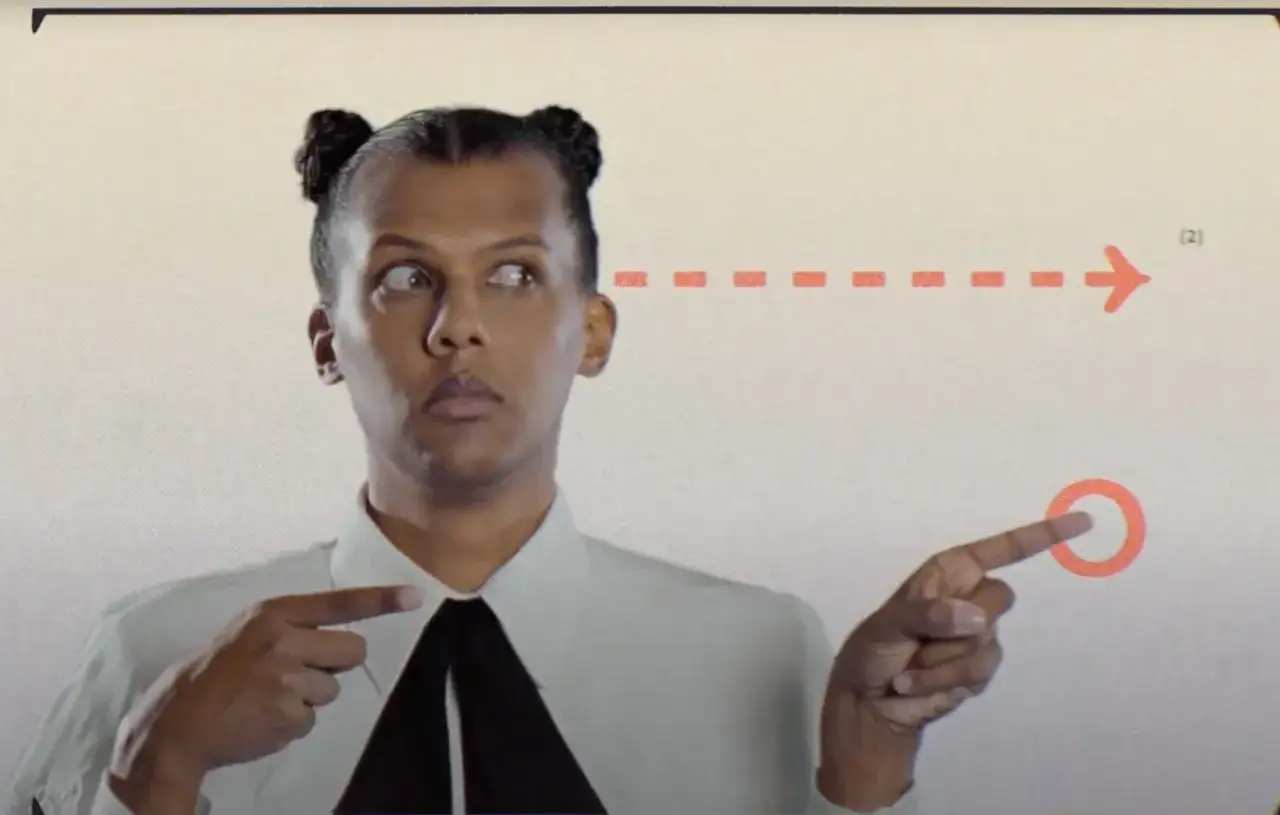 Stromae Polska: artysta z charakterystycznymi kucykami wskazuje na pomarańczową strzałkę i okrąg, jakby planował trasę koncertową.