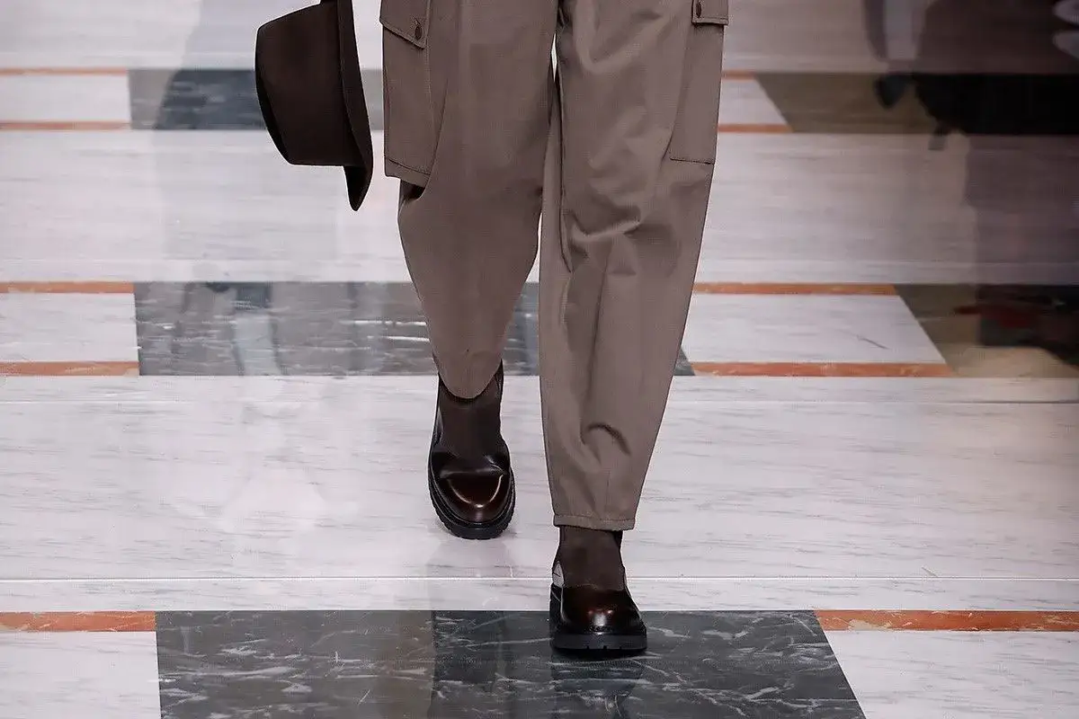 Un uomo sfoggia un outfit con pantaloni cargo marroni e eleganti stivaletti marroni uomo.