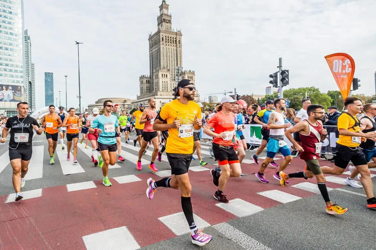 Uczestnicy biegną w p&oacute;łmaratonie warszawskim 2026. W tle Pałac Kultury i Nauki.