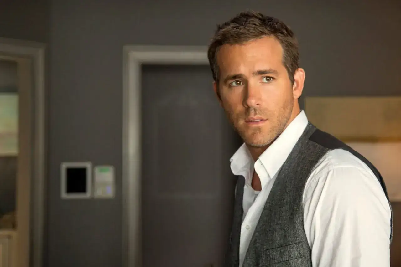 Ryan Reynolds w eleganckiej kamizelce i białej koszuli, gotowy do kolejnych ról w swoich filmach.