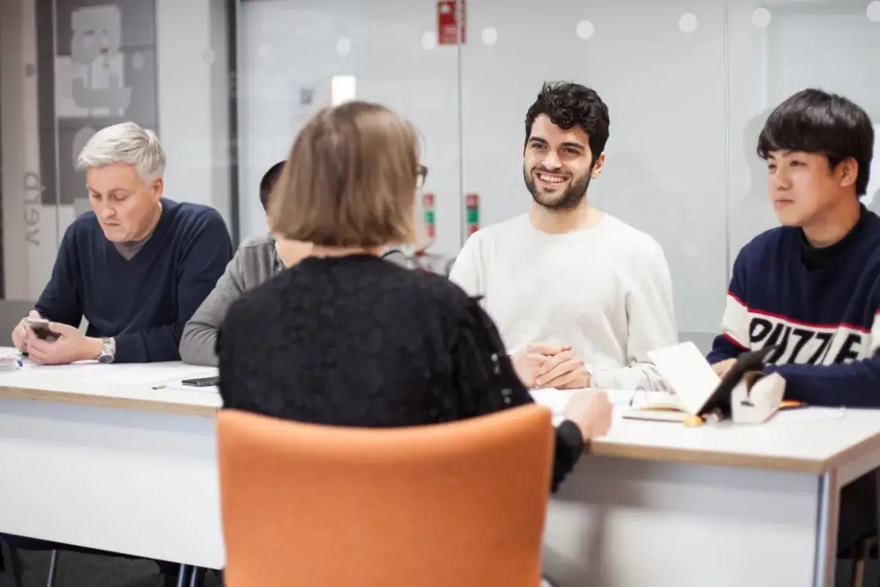 Estudiantes de diversas edades y orígenes participan en una clase para aprender inglés en Irlanda.