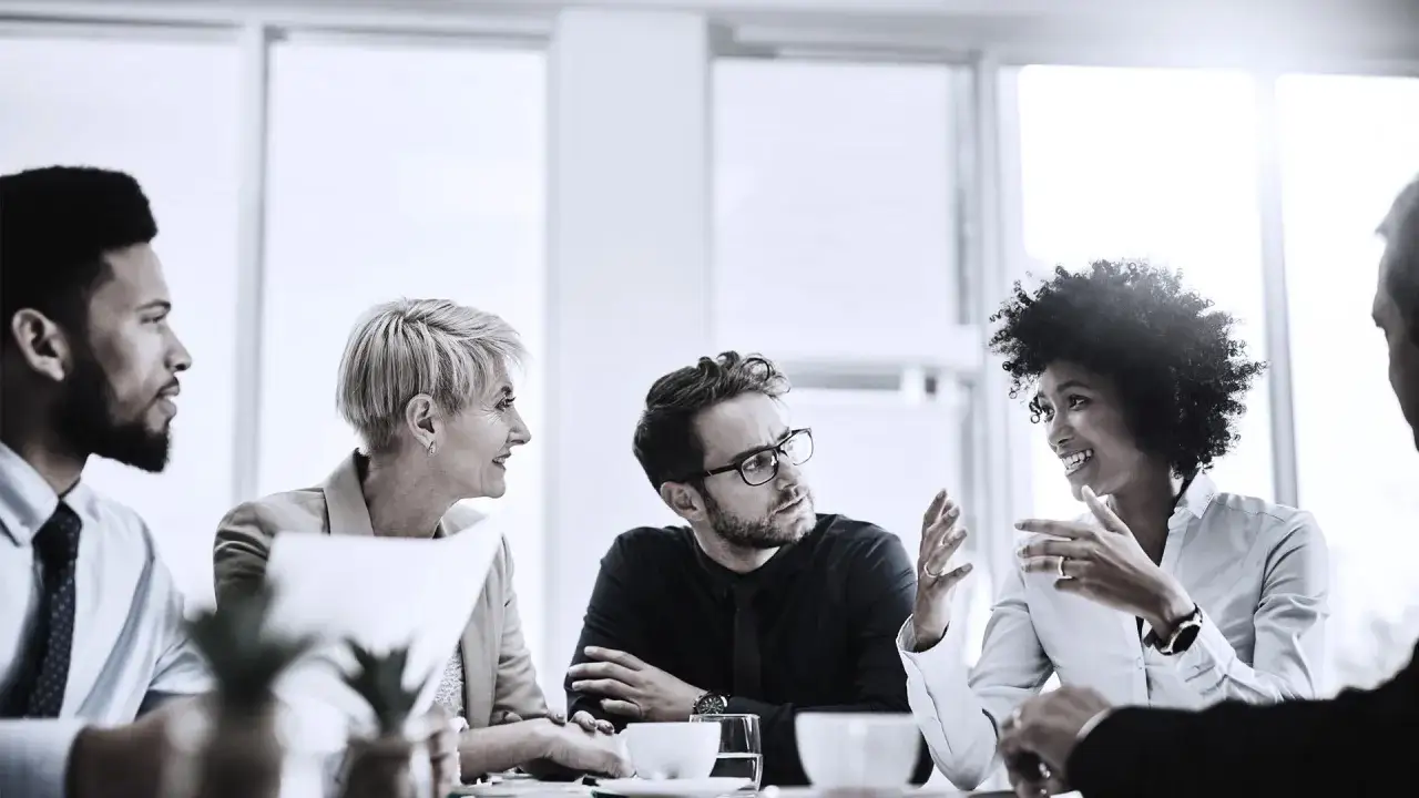 A diverse team collaborates, ideas leading below the surface as they discuss business.