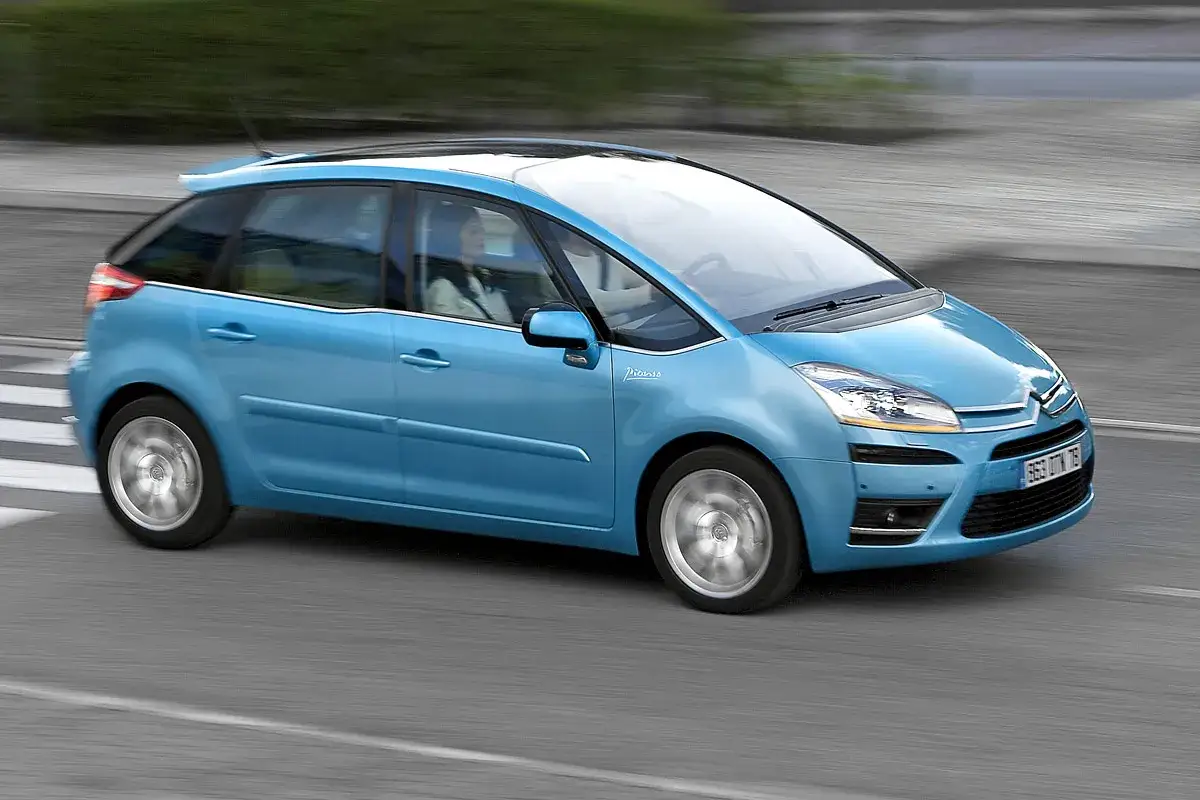 Un Citro&euml;n Picasso azul circula por la carretera, con el sol reflej&aacute;ndose en su techo panor&aacute;mico.