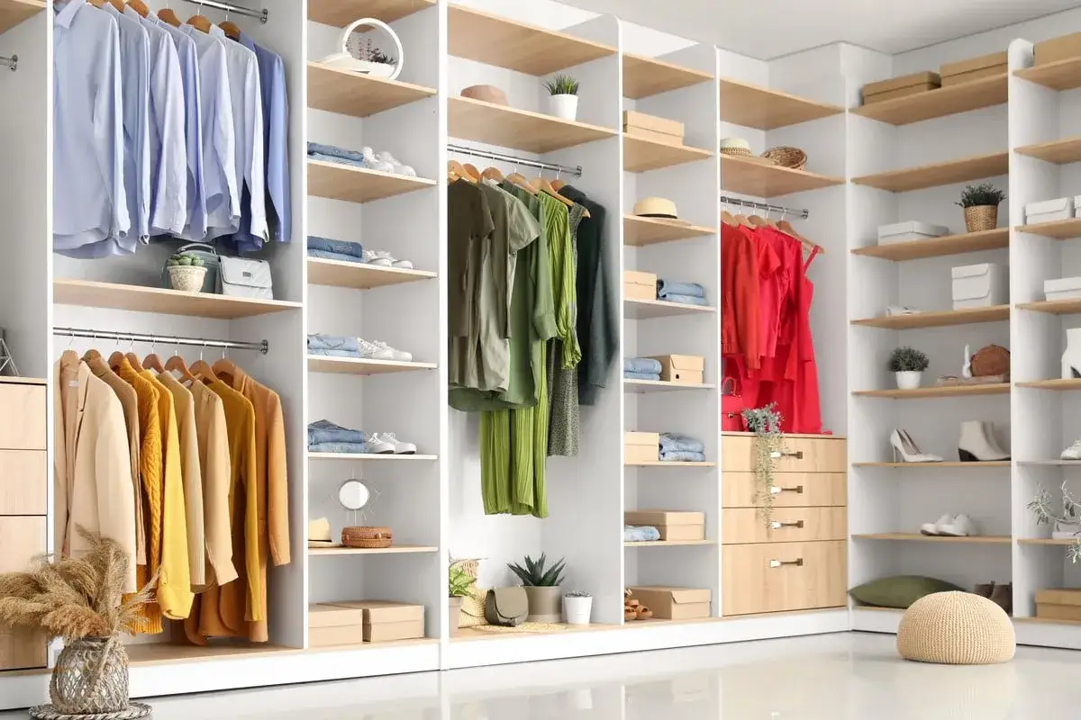 Un dressing bien rang&eacute; avec des v&ecirc;tements suspendus et pli&eacute;s, des chaussures et des accessoires organis&eacute;s sur des &eacute;tag&egrave;res.