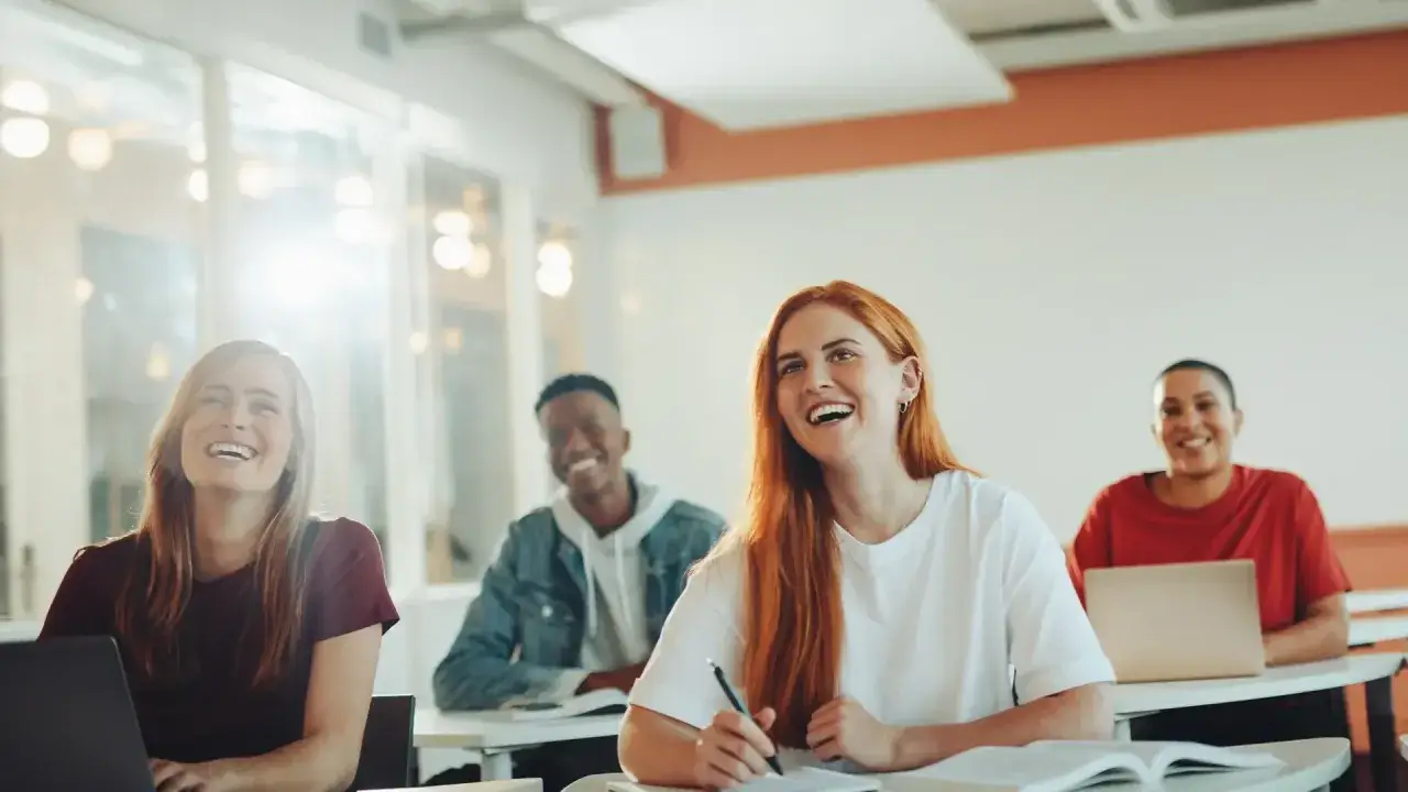 Glada studenter i klassrummet, redo för sina tvååriga utbildningar.