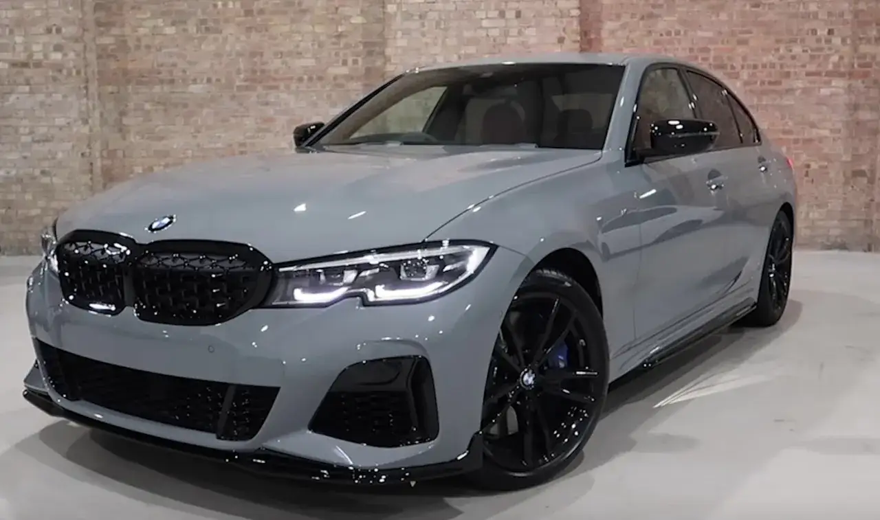 Un elegante color gris coche BMW M3, con detalles negros y llantas deportivas, listo para la carretera.