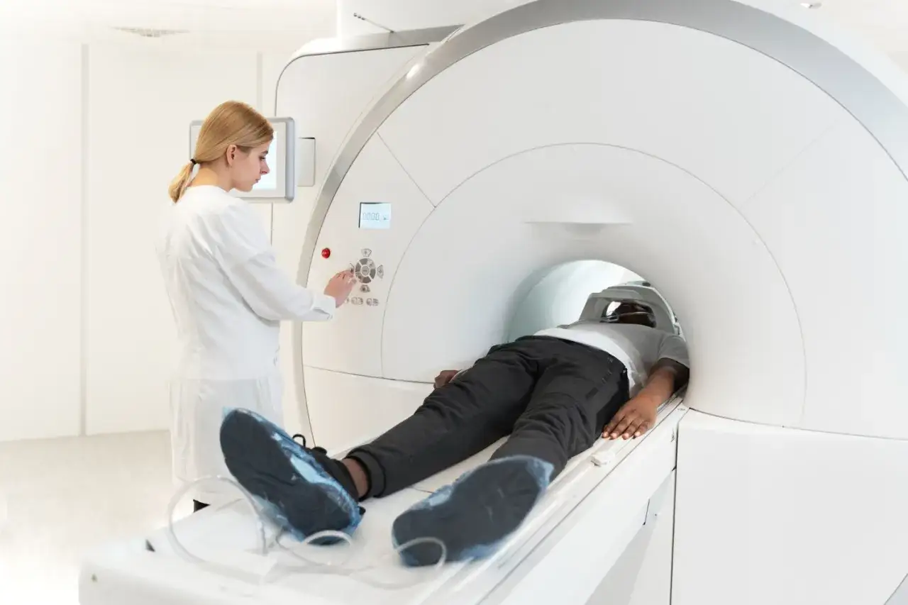 Pacjent leży w aparacie MRI, a technik przygotowuje badanie. Bez kontrastu, aby uniknąć powikłania po rezonansie magnetycznym.