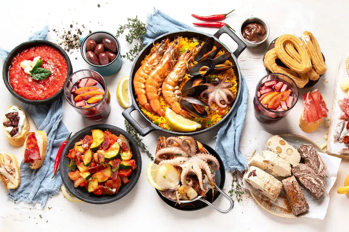 Pyszne hiszpańskie jedzenie: paella z owocami morza, tapas, churros i sangria.