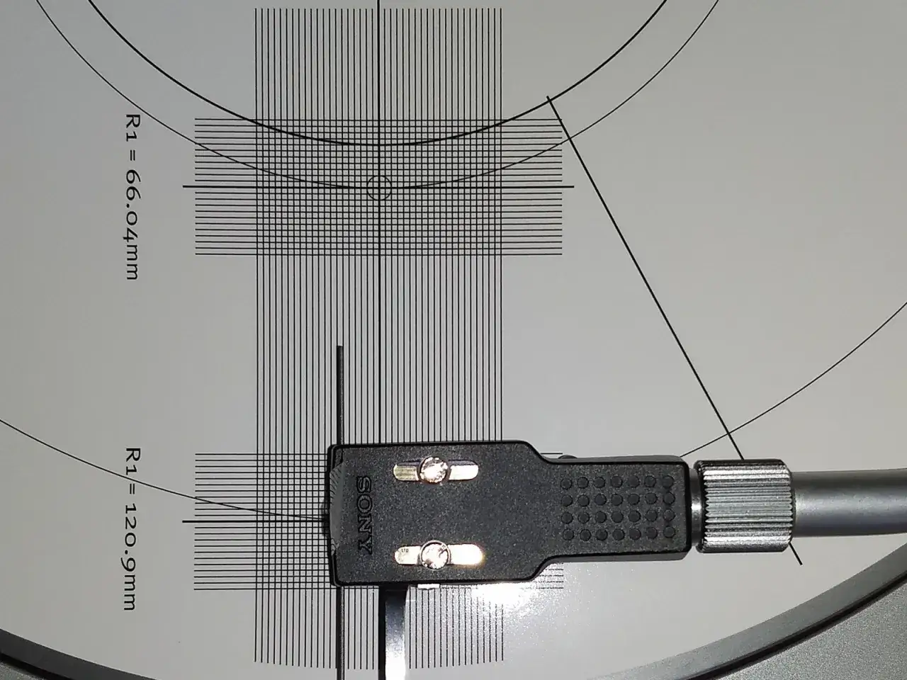 Precyzyjna kalibracja wkładki gramofonowej Sony na szablonie z liniami i wymiarami.