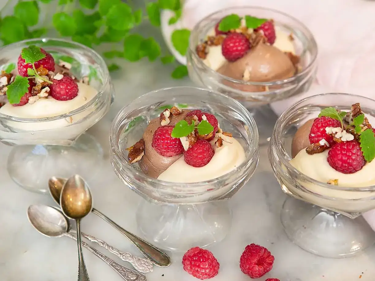 Ljuvlig choklad- och vaniljmousse i glas, toppad med hallon och nötter. Ett perfekt recept för en festlig dessert!