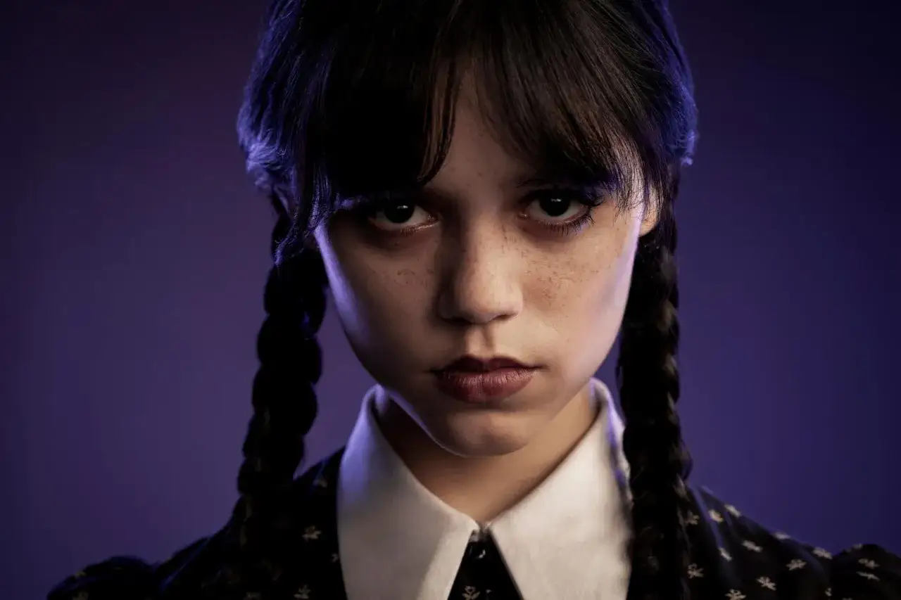 Jenna Ortega jako Wednesday aktorka, z charakterystycznymi warkoczami i spojrzeniem, w mrocznym klimacie.