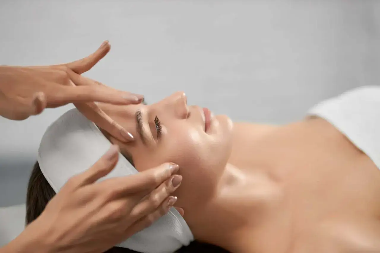 Mani esperte mostrano come massaggiare il viso per le rughe, con delicati tocchi che migliorano la pelle.