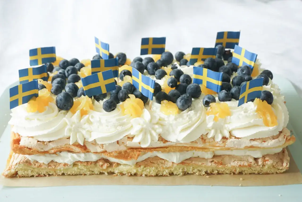 En festlig p&aring;skt&aring;rta med lemoncurd, gr&auml;dde, bl&aring;b&auml;r och sm&aring; svenska flaggor. Perfekt f&ouml;r p&aring;skfirandet!