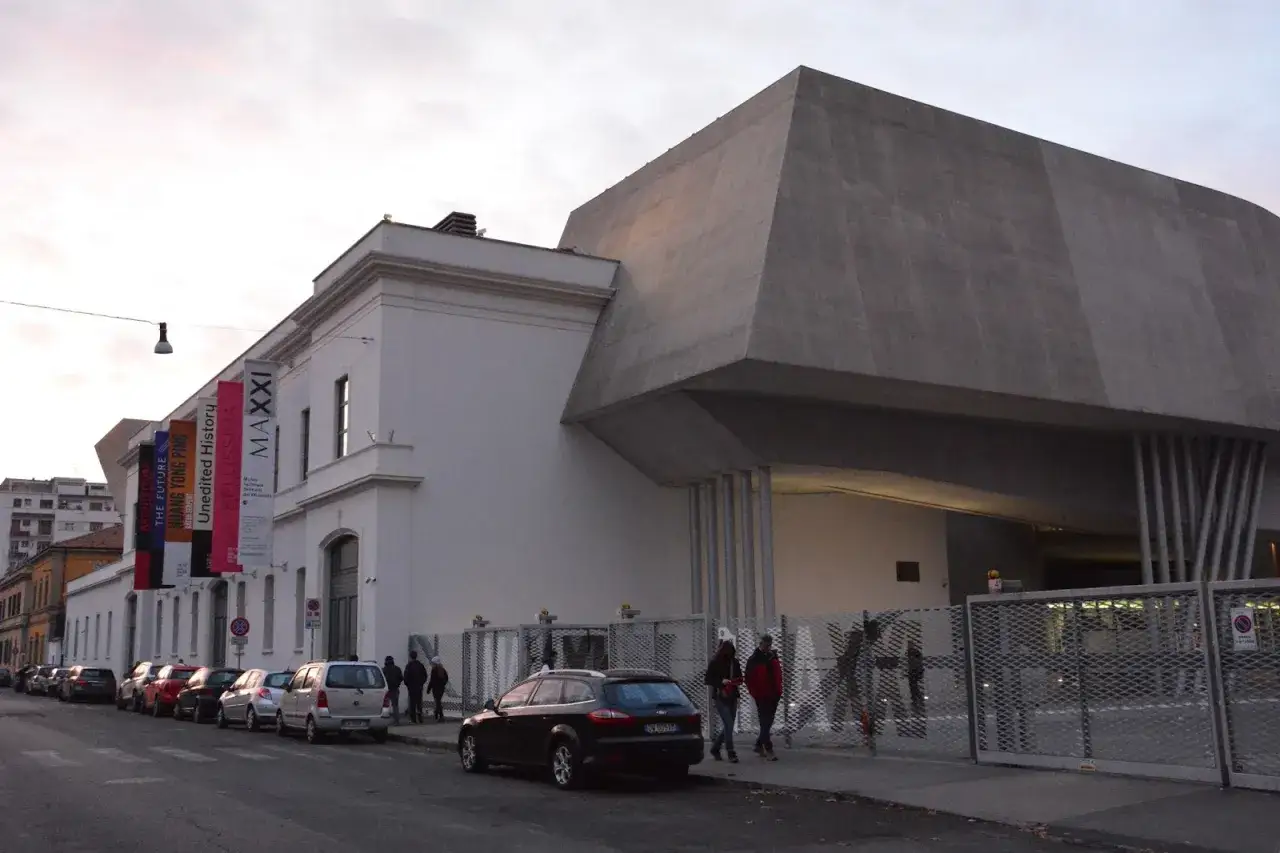 Nowoczesne muzeum sztuki współczesnej MAXXI w Rzymie, z charakterystyczną betonową bryłą i wiszącymi banerami wystaw.