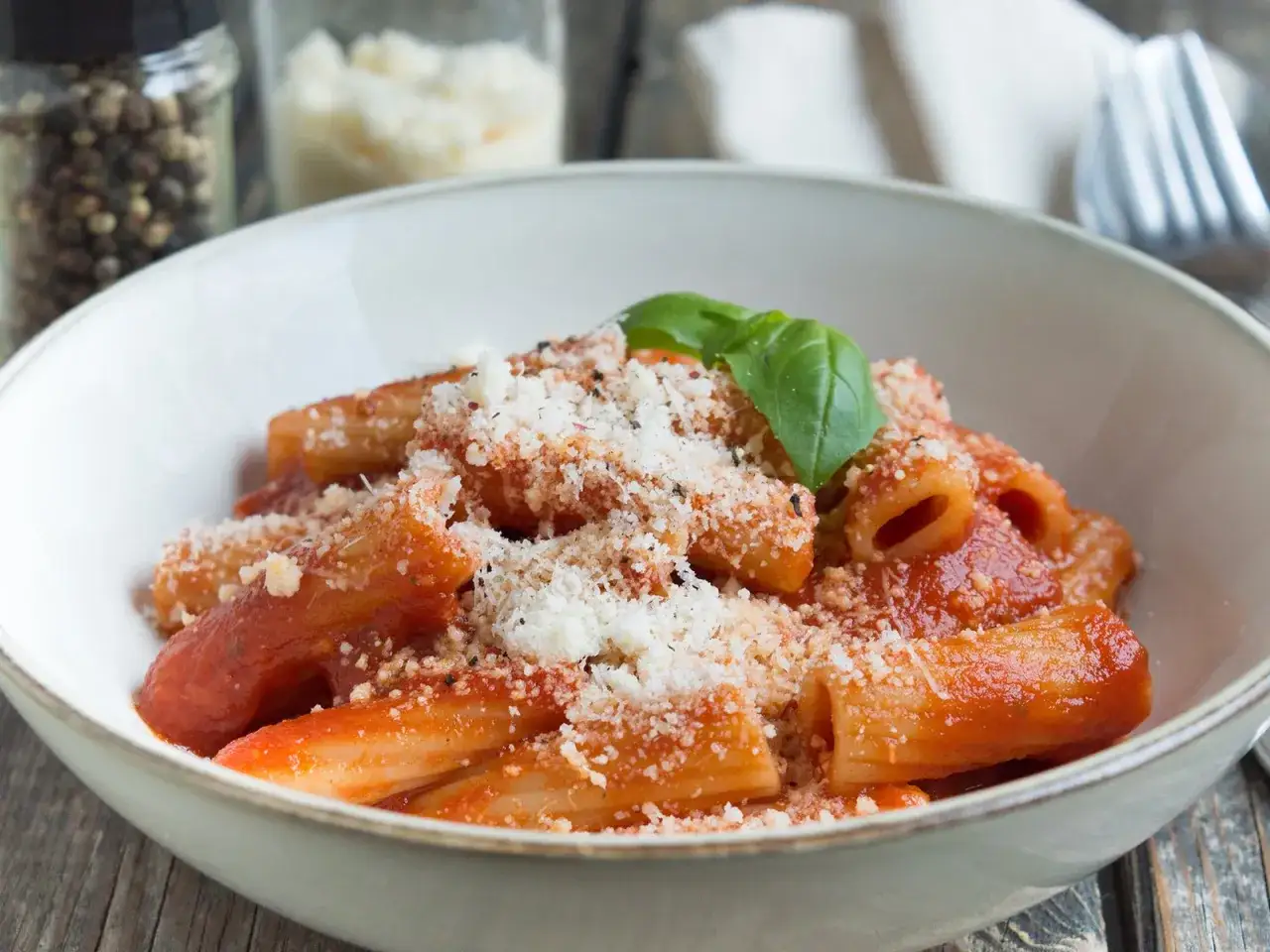 Herzhafte Paccheri-Rezepte mit Tomatensauce und Parmesan, garniert mit Basilikum. Ein Klassiker der italienischen Küche.