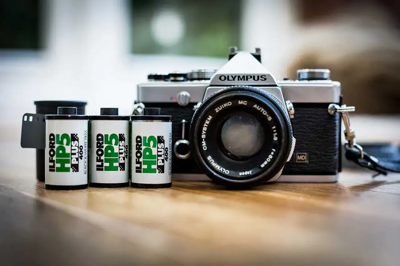 Aparat Olympus z obiektywem Zuiko i trzema rolkami czarno-białego filmu Ilford HP5 Plus. Klasyczne zdjecia z analoga.
