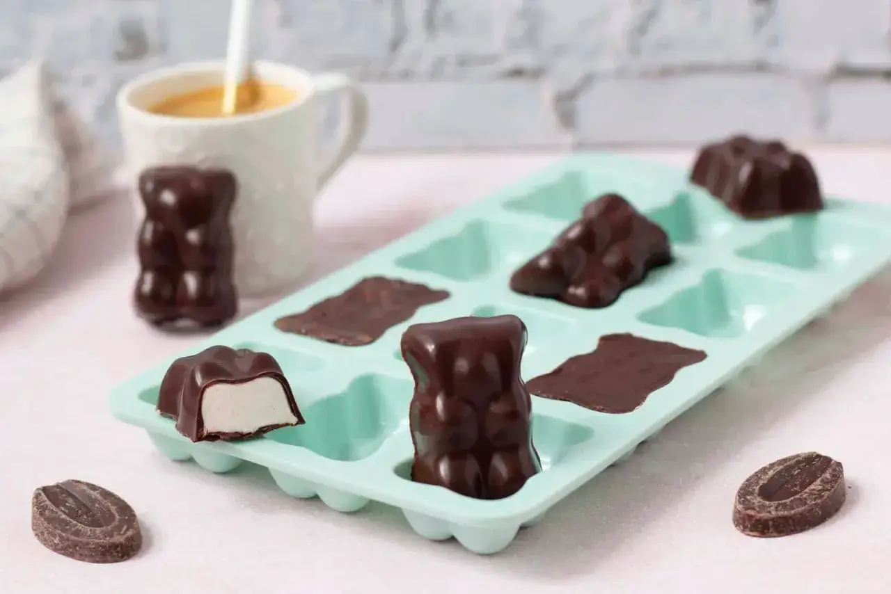 D&eacute;licieux oursons en guimauve recette, enrob&eacute;s de chocolat noir, dans un moule bleu menthe. Un d&eacute;lice &agrave; d&eacute;guster !
