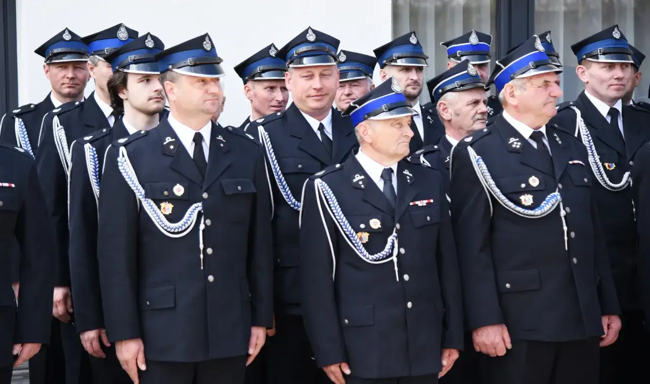 Mężczyźni w mundurach OSP, z sznurami i medalami. Pokazują, jak nosić medale na mundurze OSP, prezentując elegancję i tradycję.
