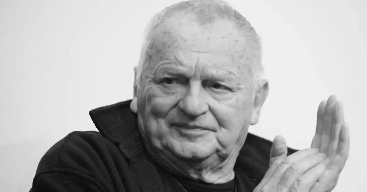 Jerzy Gruza, mistrz polskich filmów, seriali i programów, z charakterystycznym uśmiechem i dłońmi złożonymi w geście.