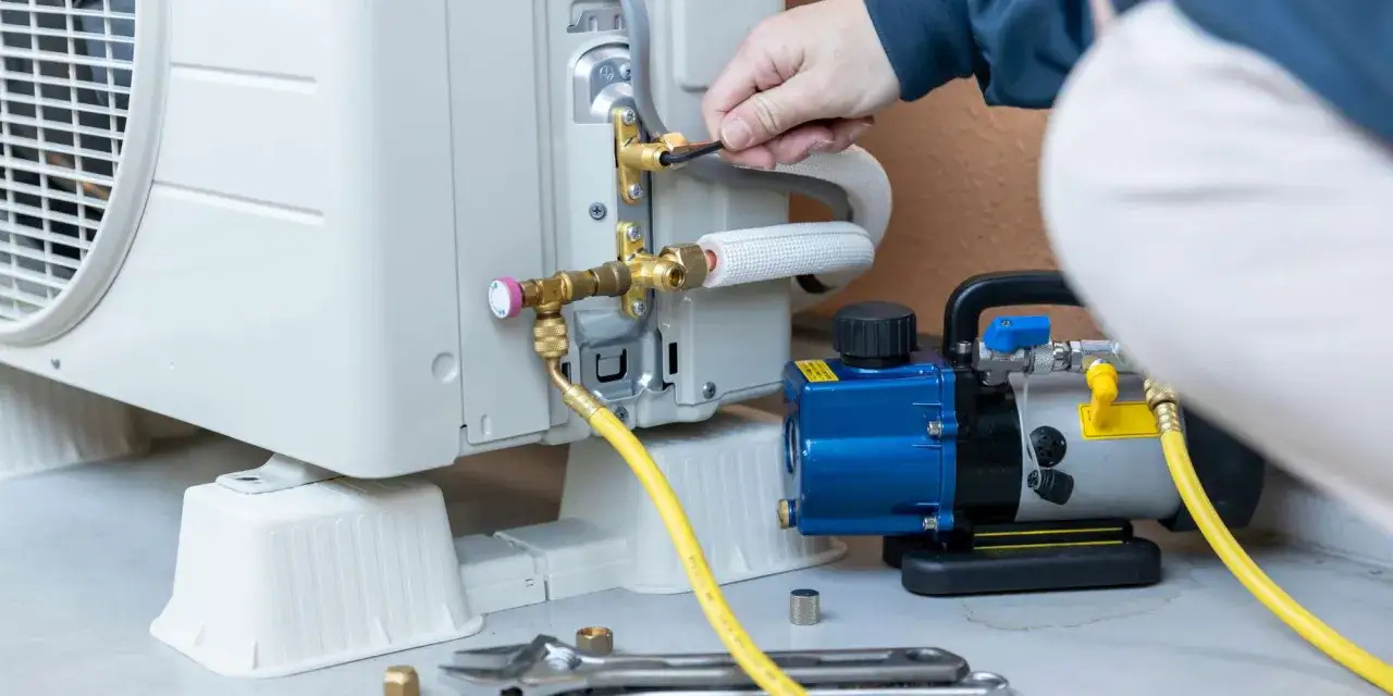 Technicien connectant une pompe de relevage à un climatiseur. L'entretien régulier optimise la durée de vie pompe de relevage climatisation.
