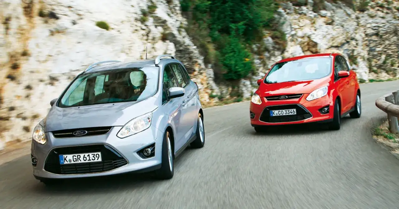 Dwa Fordy C-Max jadące krętą drogą. Poznaj ford c max wymiary i możliwości tego wszechstronnego auta.